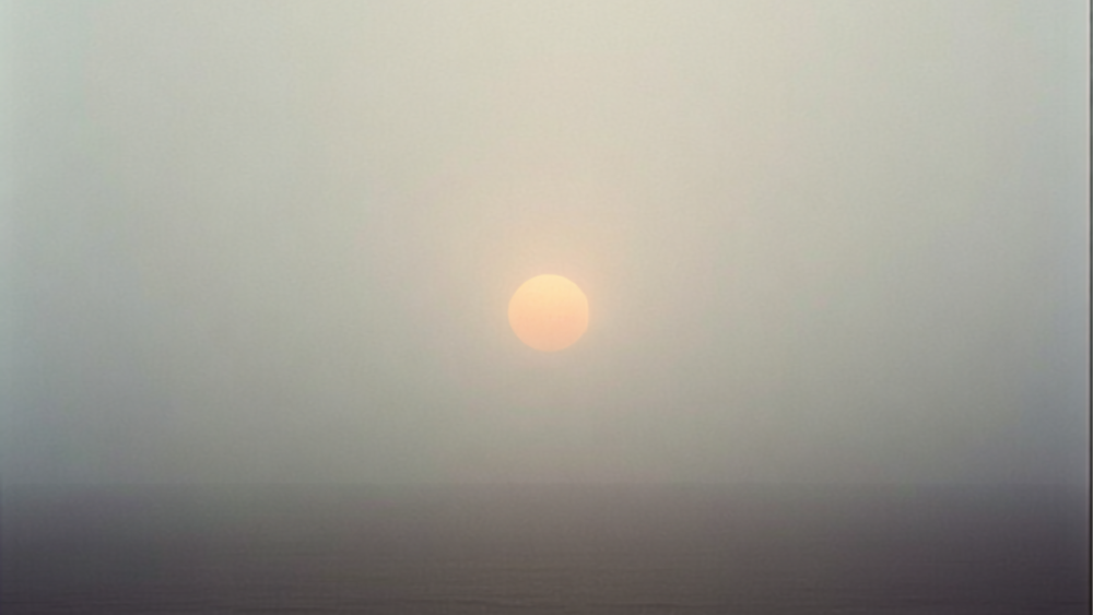 A soft, hazy sunrise over a quiet horizon, representing why we don't get to decide when life ends.