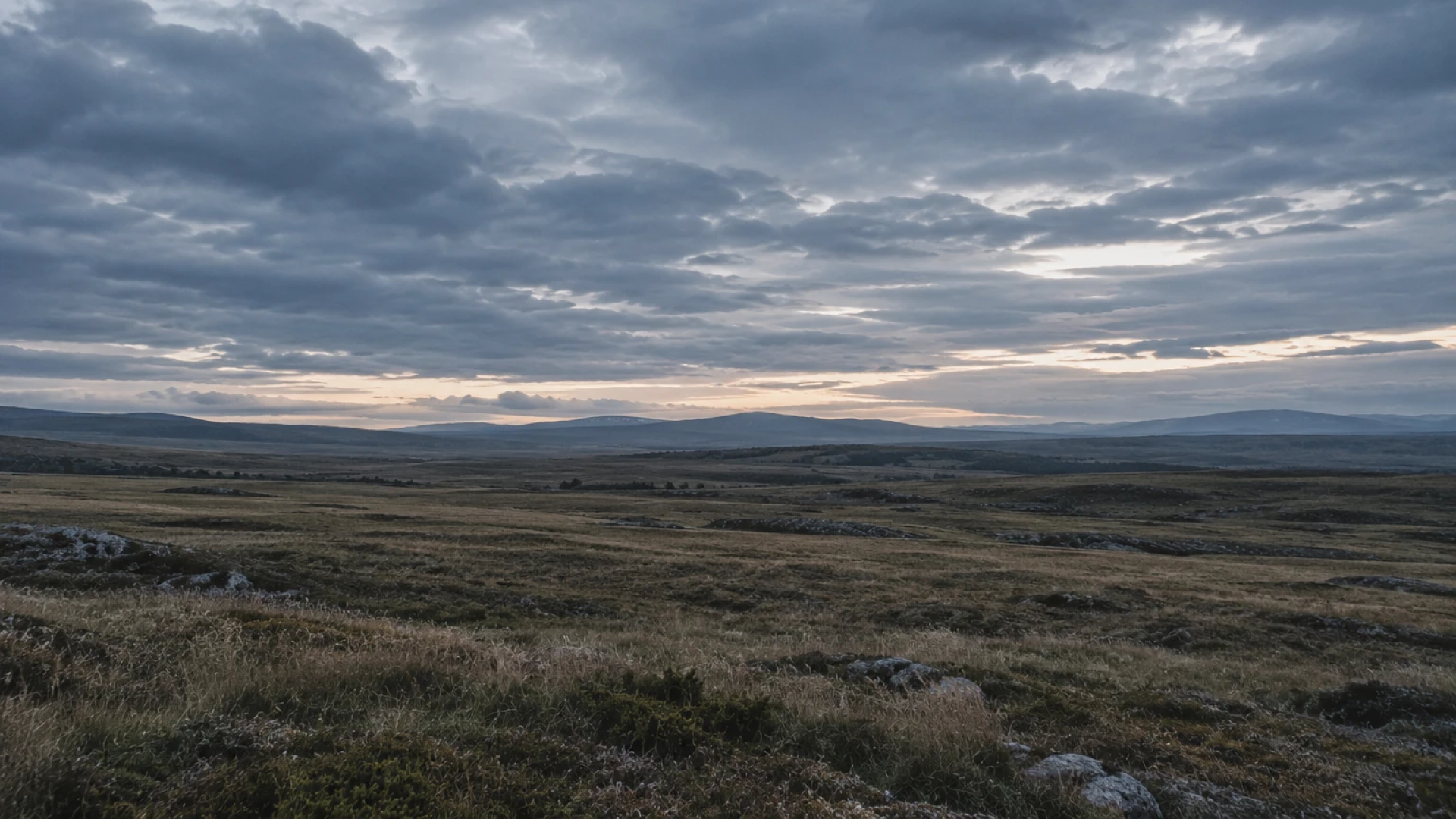 A vast, open field stretching toward distant hills under a wide sky, representing that prayer isn't about the words.